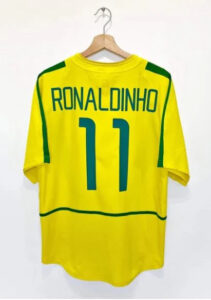 Yellow Brazil soccer jersey with Ronaldo 11 on a wooden hanger.