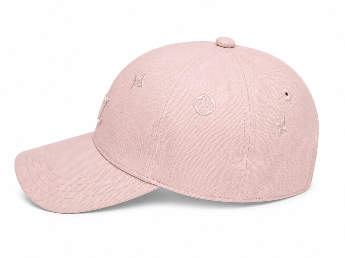 Light pink baseball cap with small embroidered flower and star motifs on the panels and a curved brim.