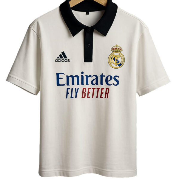 White Real Madrid polo shirt on a hanger with a black collar, featuring Adidas logo, club crest, and Emirates Fly Better sponsor text.