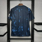 Back view of a dark blue athletic jersey with light blue splatter pattern hanging on a wooden hanger in a metal display rack.