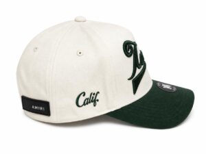 White baseball cap with green brim and 'Calif.' embroidery, AMIRI tag on back