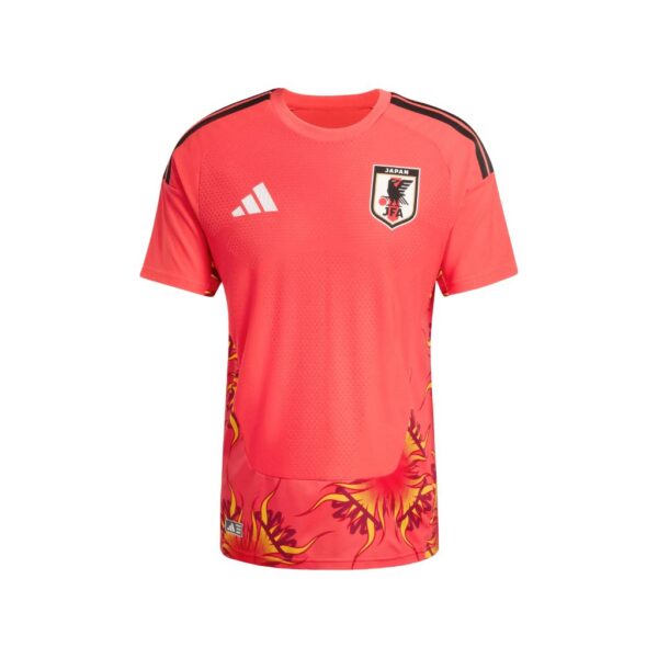 Red-pink soccer jersey with JFA crest and Adidas logo, flaming yellow pattern at the hem and shoulders, short sleeves, round neck.
