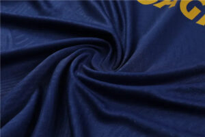 Close-up of dark navy fabric twisted into a spiral, showing smooth folds and texture.