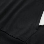 Close-up of black fabric with a neat seam, likely part of a suit or blazer material.