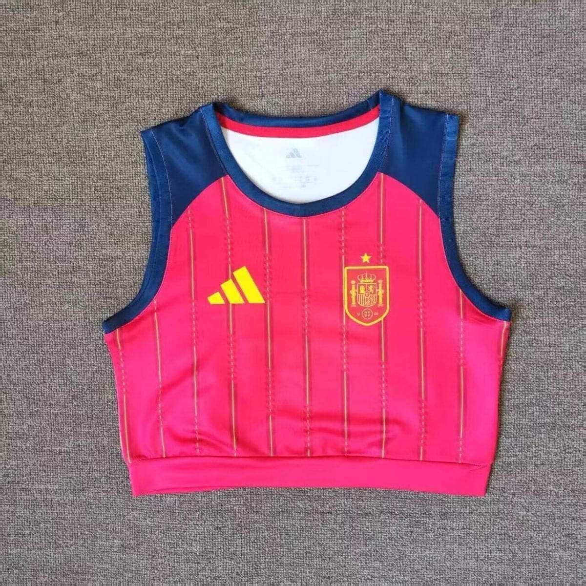 Pink sports training vest with navy shoulders, Spain national crest on the chest and an Adidas logo on the opposite side
