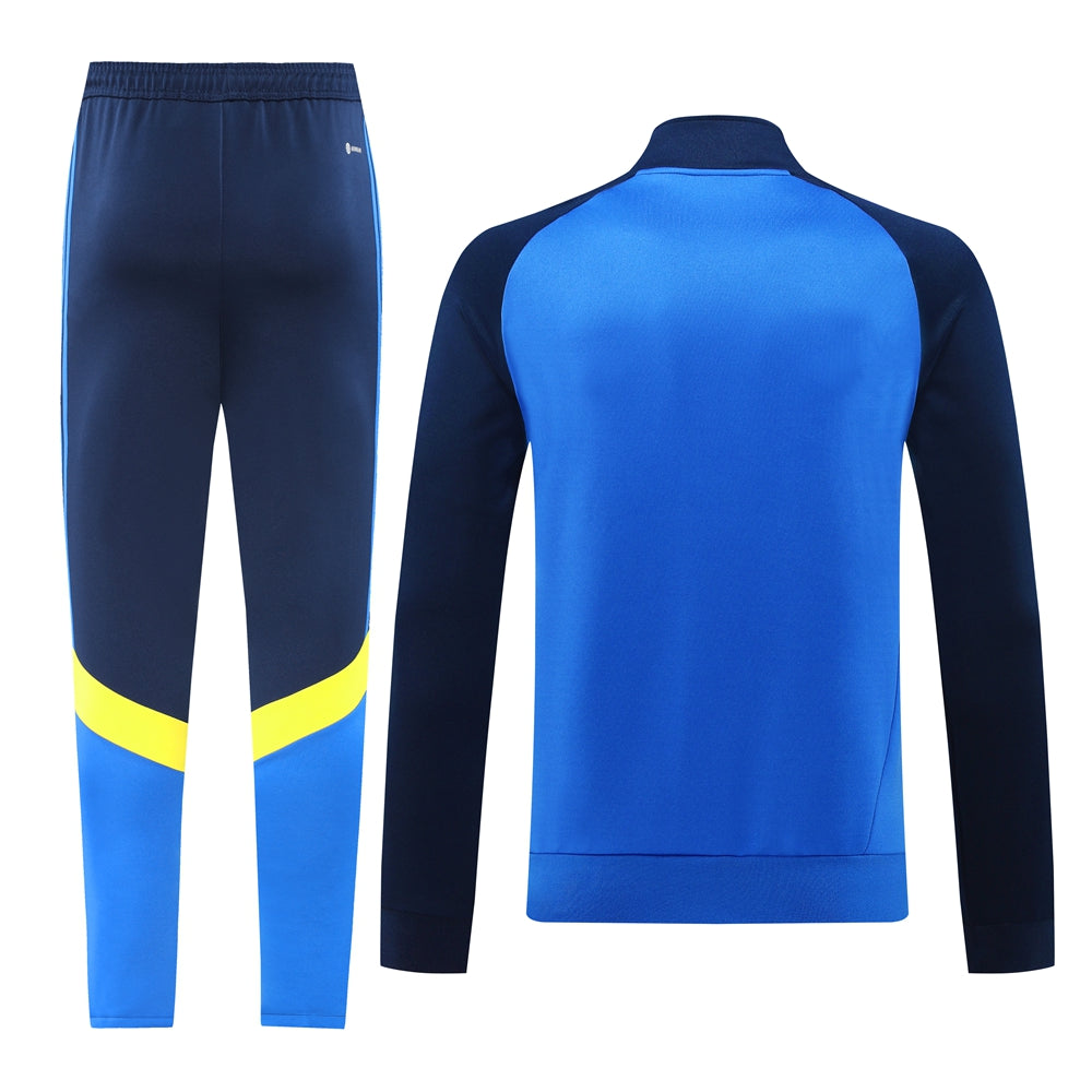 c4b56b63 | UAE SPORT STORE Athletic tracksuit: blue and navy jacket with matching pants, yellow stripe near the lower legs on the pants