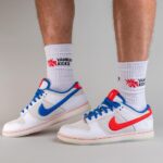 Pair of white sneakers with blue and red accents, worn with white Yankees-themed socks reading 'YANKEE KICKS'.