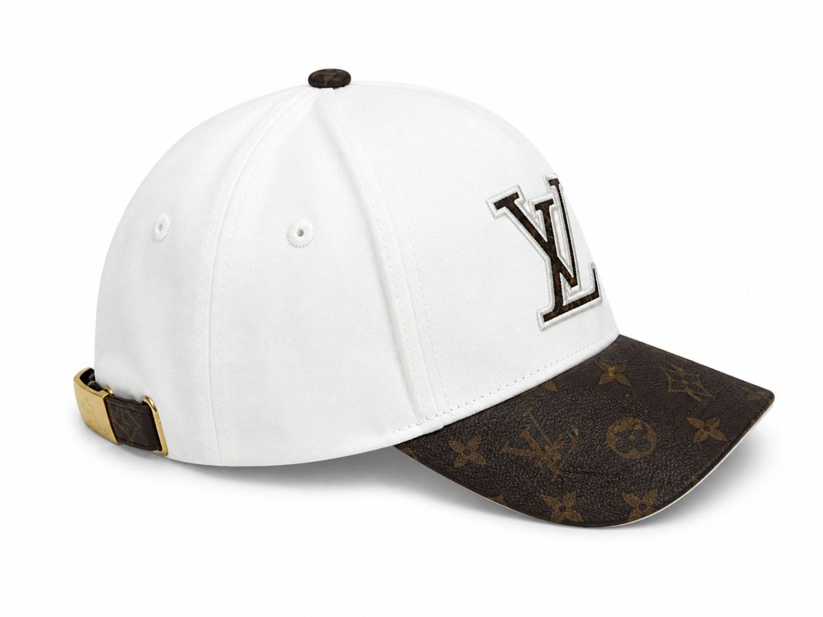 White baseball cap with a brown Louis Vuitton monogrammed brim and an LV logo on the front panel.
