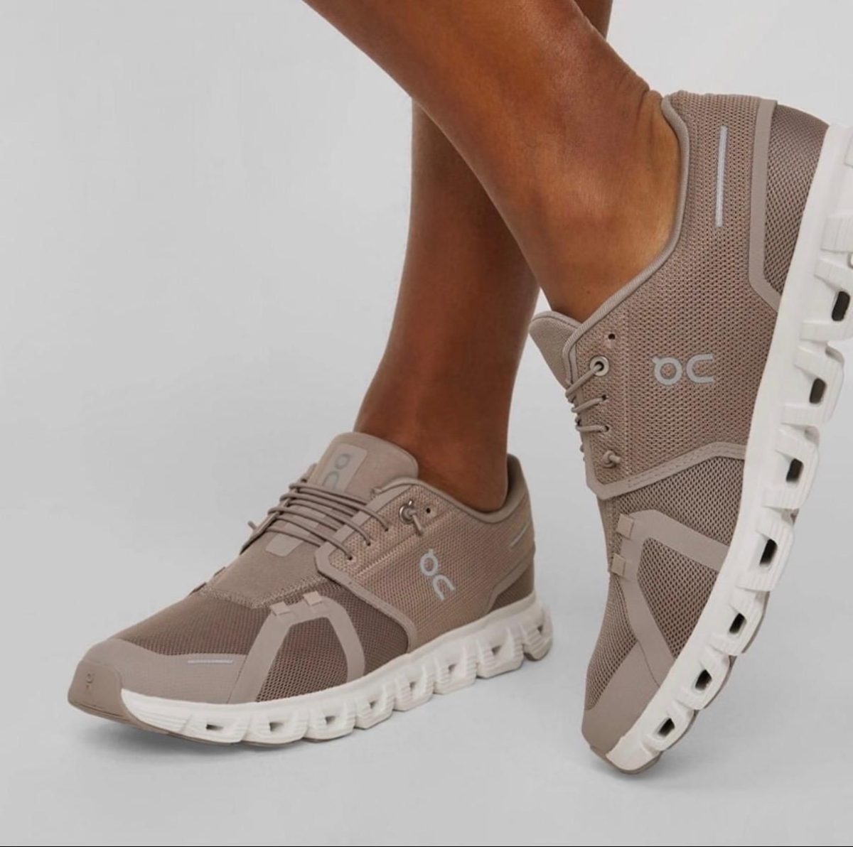 Beige breathable-mesh athletic sneakers with a thick white sole and laced front, OC logo on the side.