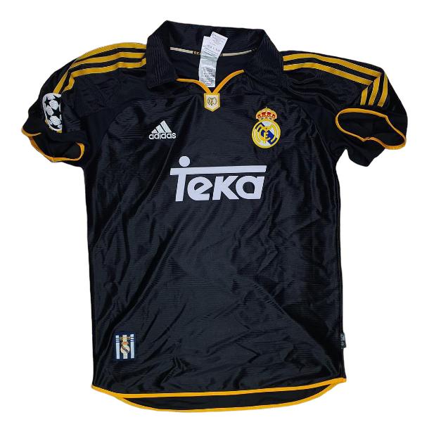 Black Real Madrid football jersey with yellow trim and stripes, featuring Adidas logo, Real Madrid crest, and 'teka' sponsor across the front.