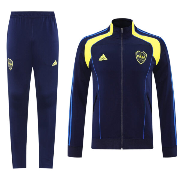 Navy blue Adidas tracksuit with yellow accents; zip-up jacket with club crest and matching pants.