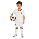 Smiling boy in a white soccer uniform holding a soccer ball