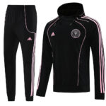 Black Adidas tracksuit with pink piping: hooded zip-front top and matching jogger pants, pink stripes along sleeves and legs, Adidas logo and chest crest visible