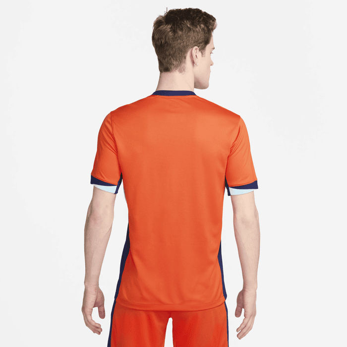 c80906ca_0335_42bb_b171_d5e77bd68678 | UAE SPORT STORE Back view of a man wearing an orange athletic jersey with navy trim and blue cuffs.