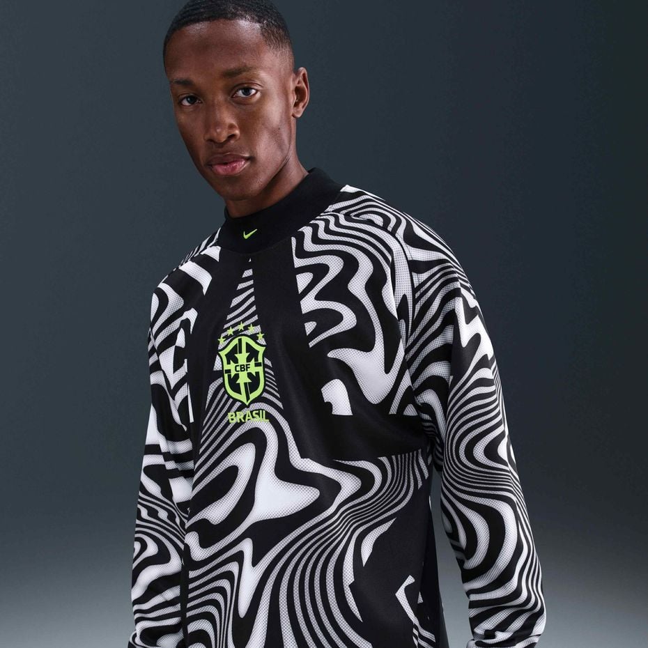 c8cdc6b7-d951-4495-b37d-bd343b34b446 | UAE SPORT STORE Portrait of a person wearing a bold black-and-white swirl-pattern Brazil jersey with a neon green crest on the chest.