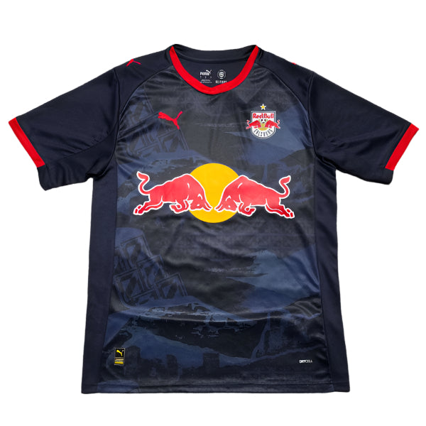 Dark blue Red Bull soccer jersey with a large Red Bull logo on the front over a yellow circle, team crest on the left chest, Puma logo on the right, and red trim on the collar and sleeves.