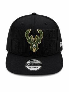 Black snapback cap featuring the Milwaukee Bucks logo embroidered in green and gold on the front panel, with a New Era 9FIFTY badge on the brim.