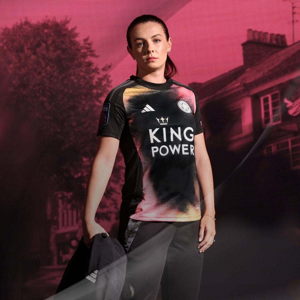 Athlete standing on stage in a black sports jersey with a 'KING POWER' logo against a pink backdrop.