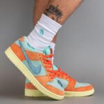 Colorful high-top sneakers in orange, teal, and cream being worn with white crew socks.