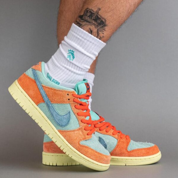 Colorful high-top sneakers in orange, teal, and cream being worn with white crew socks.