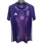 Purple athletic jersey with pink ornamental floral pattern and Arabic crest on the chest, Adidas logo visible on the left.