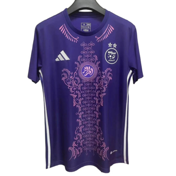 Purple athletic jersey with pink ornamental floral pattern and Arabic crest on the chest, Adidas logo visible on the left.