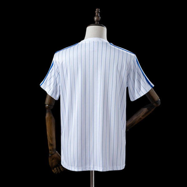 Back view of a white baseball jersey with blue pinstripes on a mannequin against a black background.