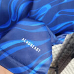 Close-up of blue athletic fabric with the 'AEROREADY' logo visible
