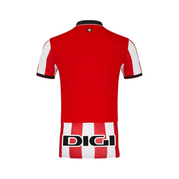 Back view of a red soccer jersey with white vertical stripes at the hem, DIGI sponsor across the lower back, and a small crest near the collar.