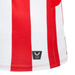 Close-up of a white jersey with bold red vertical stripes and a black Castore product badge at the hem.