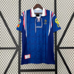 cbc551c30371f0f3cb5da2fc793507e1 | UAE SPORT STORE Blue adidas football jersey on a hanger with a lace-up collar, red-white trim, and patches on the sleeves; dark blue panels and subtle pattern throughout.
