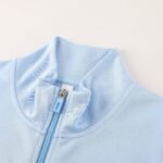 Close-up of a light blue zipper on pale blue fabric.