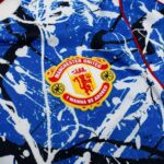 Close-up of blue patterned fabric with a Manchester United badge partially visible