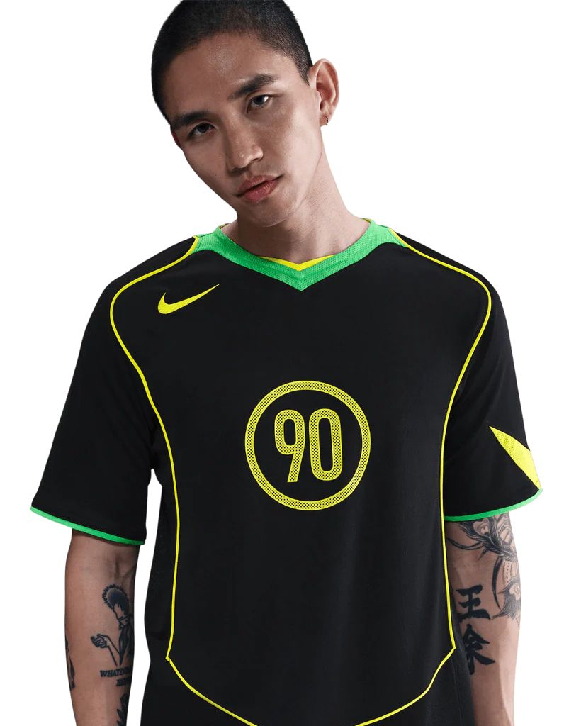 ce571e23-48e3-4646-92ab-b74ba9e39b48 Young man wearing a black sports jersey with neon green trim and the number 90 on the chest.