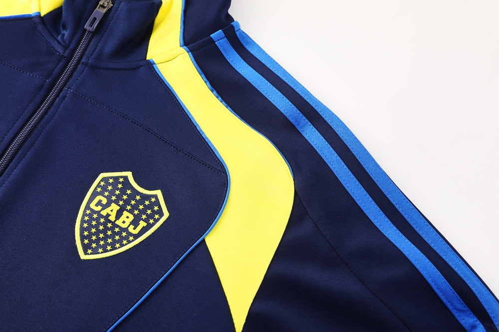 cedcb783 | UAE SPORT STORE Navy sports jacket with a bright yellow panel and blue stripes; CABJ shield emblem on the chest.
