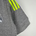Grey sweatshirt sleeve with three neon yellow reflective stripes along the shoulder area, on a light background.
