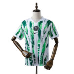 White soccer jersey with a green palm-leaf pattern, featuring the Nigeria Football Federation badge on the chest and a black Nike logo on the front.