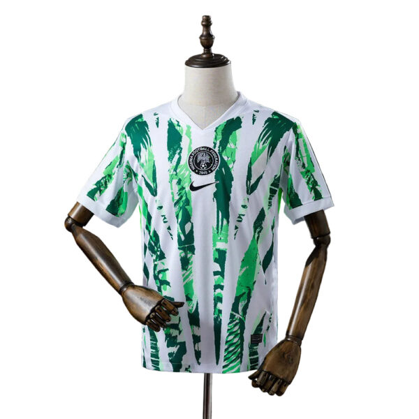 White soccer jersey with a green palm-leaf pattern, featuring the Nigeria Football Federation badge on the chest and a black Nike logo on the front.