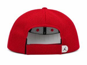 Rear view of a red mesh baseball cap with an adjustable strap and a white tag featuring the Jordan Jumpman logo on the side.