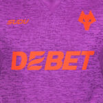 Purple athletic jersey chest with bright orange 'DEBET' text and a small orange fox-like logo on the right side.
