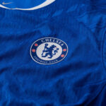 chelsea-nike-dri-fit-adv-home-match-shirt-2025-26_ss5_p-202492466_pv-10_u-3mnhc49rbj95yqjqpcho_v-oiueiv8z06yxtwxs5vts | UAE SPORT STORE Chelsea Football Club crest on a blue jersey, featuring the lion and circular badge design