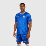 chelsea-nike-dri-fit-adv-home-match-shirt-2025-26_ss5_p-202492466_pv-1_u-3mnhc49rbj95yqjqpcho_v-nau7nw3twrtuhv1idabv | UAE SPORT STORE Male model wearing Chelsea FC blue home soccer kit with crest and white Nike swoosh, standing against a neutral backdrop.
