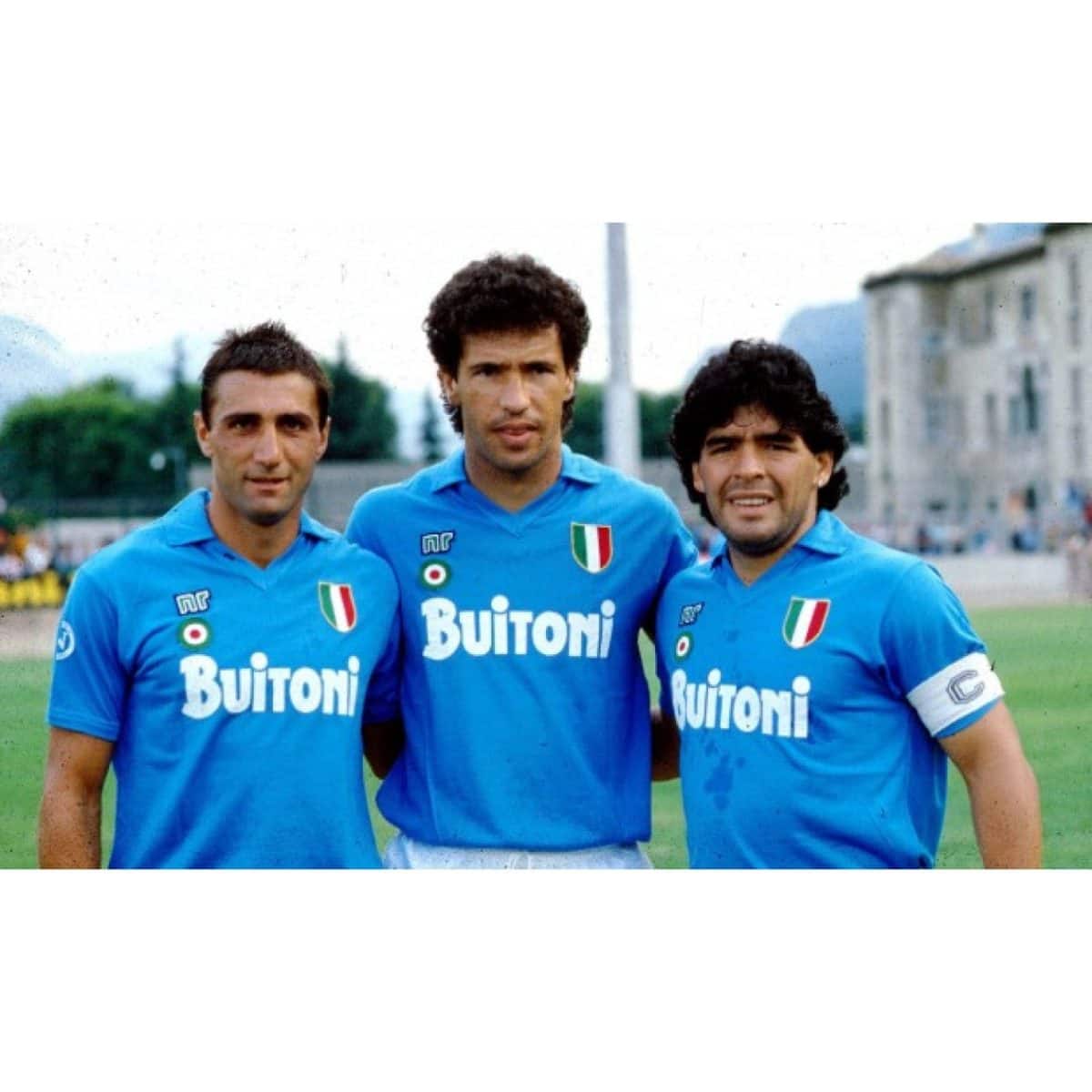Three male soccer players in matching blue jerseys with Buitoni sponsor posing together on a grassy field.