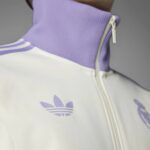 Close-up of a lavender sneaker collar with a white zipper and a lavender Adidas trefoil logo on white fabric, cropped view