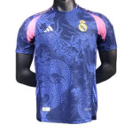 Blue Real Madrid football jersey with a dragon pattern, pink shoulder panels, Adidas logo, and team crest on the chest.