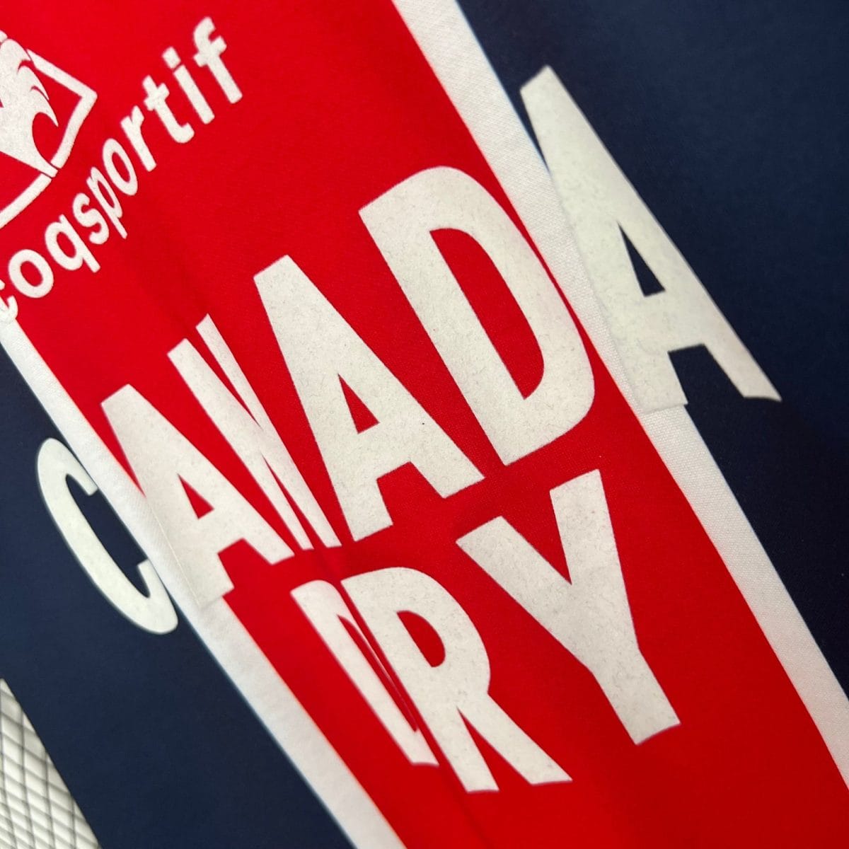 Close-up of a red poster with large white bold letters diagonally across a dark blue background.