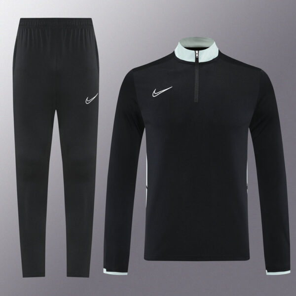 Black Nike tracksuit: zip-neck top and matching joggers with white swoosh logos for a minimalist athletic look