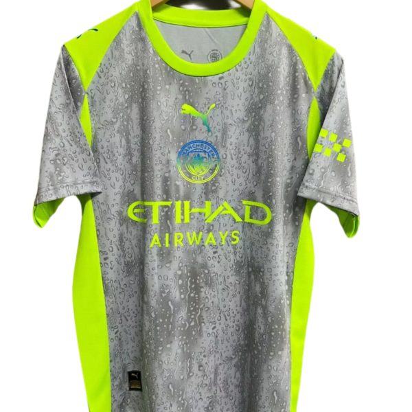 Manchester City away jersey on a wooden hanger, neon yellow and grey with a rain-drop pattern and sponsor logos (Etihad).