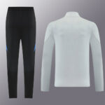 Two-piece athletic set: black leggings with blue accents paired with a light gray long-sleeve top seen from the back.