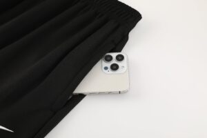 d3df1abf | UAE SPORT STORE Silver iPhone with triple cameras resting on a white surface beside a black elasticated garment.